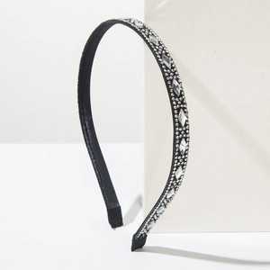 Detail of a thin black headband featuring intricate round and diamond-shaped rhinestones