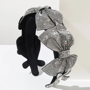 Close-up of black headband with four layered bows encrusted with sparkling silver rhinestones