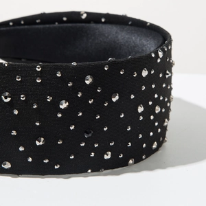 Detail shot of a black wide headband with sparkling silver rhinestones on knit fabric