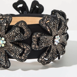 Close-up of black velvet headband with grey rhinestones and colorful floral details