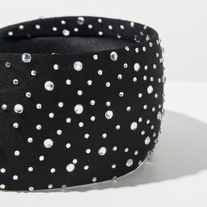 Detailed close-up showing the wide black fabric headband with sparkling white rhinestones
