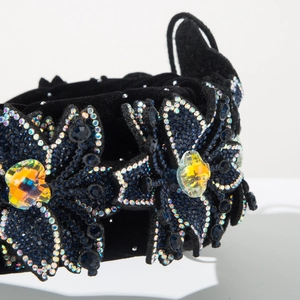 Macro shot of luxury velvet headband featuring intricate blue rhinestone floral embroidery