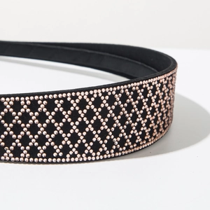 Macro detail of rose gold rhinestones set on black velvet headband with grid pattern