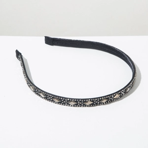 Detail view of vintage black headband featuring rhinestone diamond accents and pearls