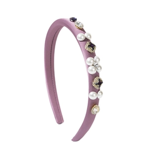Padded lavender satin headband with pearls and purple gemstones in 45-degree view