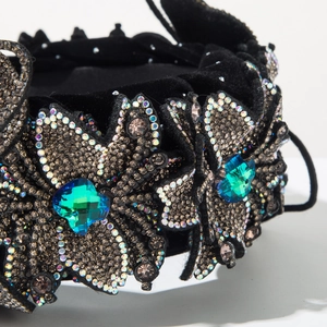Close-up of velvet headband with blue crystals and sparkling rhinestone leaf patterns