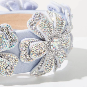 Detail of light blue satin headband featuring hand-set rhinestones in floral patterns