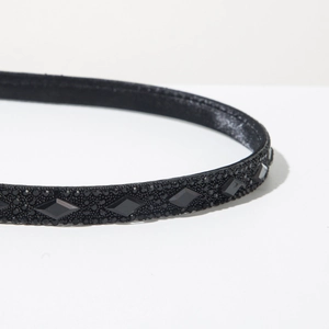 Detailed close-up of a vintage black headband featuring micro-rhinestones and diamond-cut gems