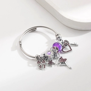 Details vom silbernen Charm-Armband mit lila Perlen und Ballett-Tänzerin Anhängern