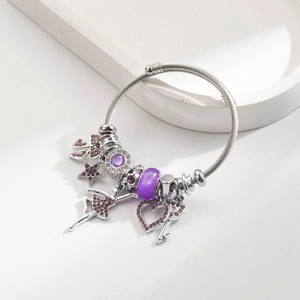 Detail eines silbernen Perlenarmbands mit lila Glasperlen und Ballett-Anhängern
