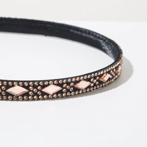 Detail view of headband featuring black fabric base with champagne micro diamonds and pink crystals