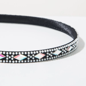 Macro shot of narrow black satin headband with three rows of white pearls and rhinestones