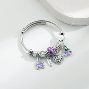 Detailansicht silbernes Armband mit lila Kristallschloss und Kirschenanhängern