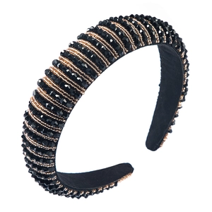 Baroque style headband with black crystal beads and gold chain detailing on white background