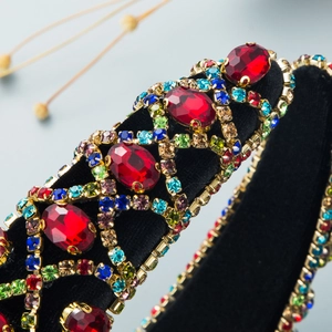 Macro detail of red rhinestones and luxury crystals on a velvet Baroque headband