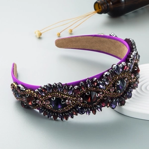 Macro shot of Baroque headband featuring purple crystals and gold bead flower patterns