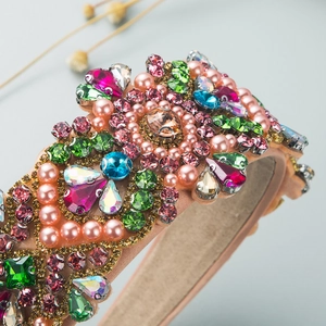 Close-up of baroque wide headband with colorful crystals and pink pearls on satin