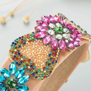 Macro detail of luxury baroque headband with intricate hand-sewn beads and pink crystals
