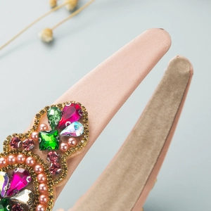 Close-up of pink baroque headband with colorful crystals, pearls and velvet lining