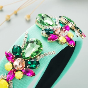 Close-up of mint green padded headband with colorful rhinestones and floral crystals