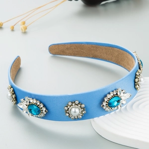 Close-up of blue wide headband featuring ornate pearls and rhinestone embellishments