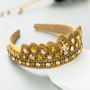 Golden Baroque crown headband with amber rhinestones on a white geometric stand