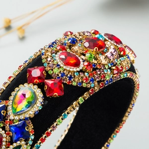 Dettaglio macro di strass colorati e intarsi in cristallo su fascia barocca in velluto