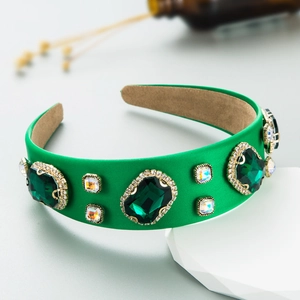 Detailed shot of green satin Baroque headband with emerald gemstones and gold claw settings