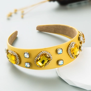 Macro detail of Baroque yellow wide headband featuring large rhinestones and satin finish