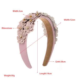 Detailed close-up showing pink fabric flowers with rhinestone centers on a padded headband