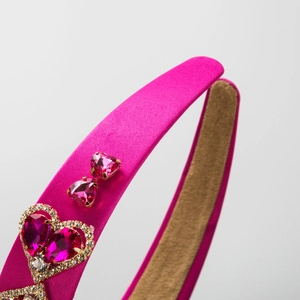 Baroque rose pink headband with heart-shaped rhinestones and satin finish on white background