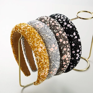 Padded floral sponge headbands with sparkling rhinestones and pearls on display rack