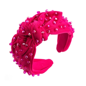 Detail showing the intricate pink crystal beadwork and knotted fabric design on the headband