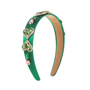 Detailed shot of emerald green baroque headband with heart-shaped rhinestones and gems