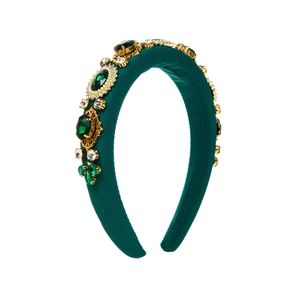 Close-up of green baroque headband with emerald gems, rhinestones and pearls