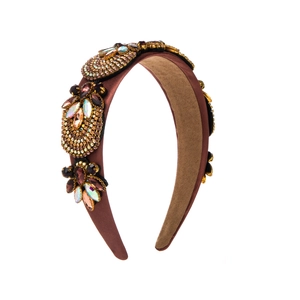 Detailed macro view of hand-stitched amber rhinestones on a vintage baroque headband
