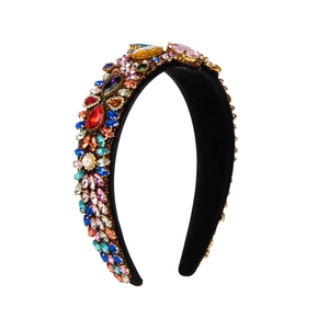 Detail of wide baroque headband with multicolored crystals and pearls on black velvet