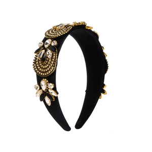Detailed view of baroque wide headband with golden embroidery and sparkling rhinestones