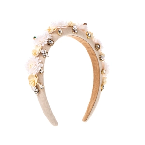 Detailed view of vintage headband with beige fabric flowers, pearls and shiny rhinestones