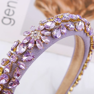 Detail of purple rhinestones and crystal flower on a baroque woven headband