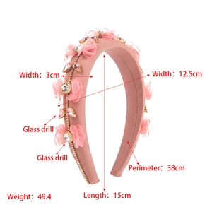 Détail du serre-tête en tissu rose avec fleurs en mousseline et cristaux scintillants
