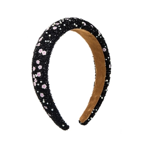 Close-up of sponge headband with pink floral accents, pearls, and a non-slip velvet lining