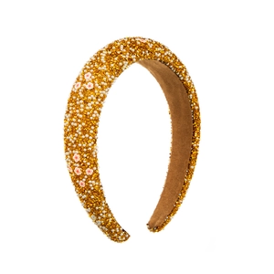 Detailed shot of padded sponge headband with golden rhinestones, pearls and pink flowers