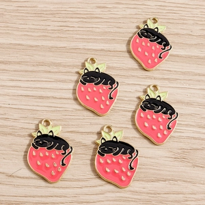 Five strawberry black cat alloy pendants with golden edges on a light wood background