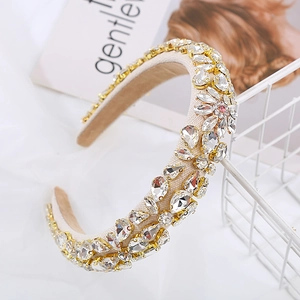 Detail of baroque headband with handmade rhinestones and floral pattern on cream fabric