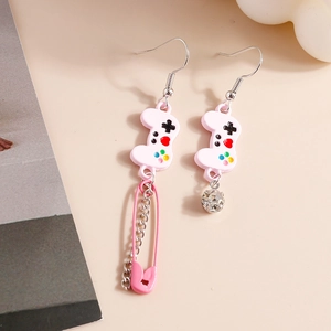 Detail of pink game controller earring with safety pin, silver chain, and rhinestone ball