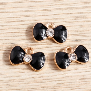Three black enamel bow pendants with crystal diamond centers and gold alloy frames