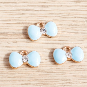 Three light blue enamel bow pendants with crystal center and gold-plated rings for DIY