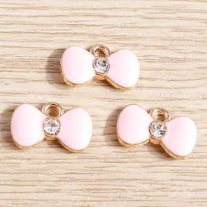 Pink enamel bow charms with crystal accents and gold-plated alloy frames for jewelry making