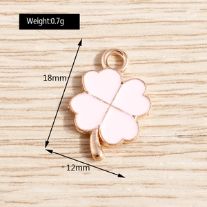 Détail macro d'un pendentif trèfle en émail rose de 12mm avec bordures dorées pour bijoux
